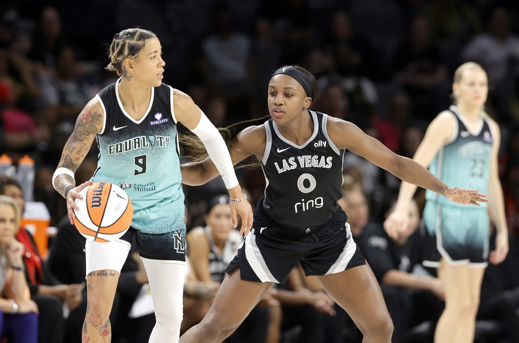 Las Vegas Aces guard Jackie Young (0) defends against New York Liberty guard Natasha Cloud (9) during the first half of a WNBA basketball game, Wednesday, Aug. 13, 2025, in Las Vegas. (Steve Marcus/Las Vegas Sun via AP)