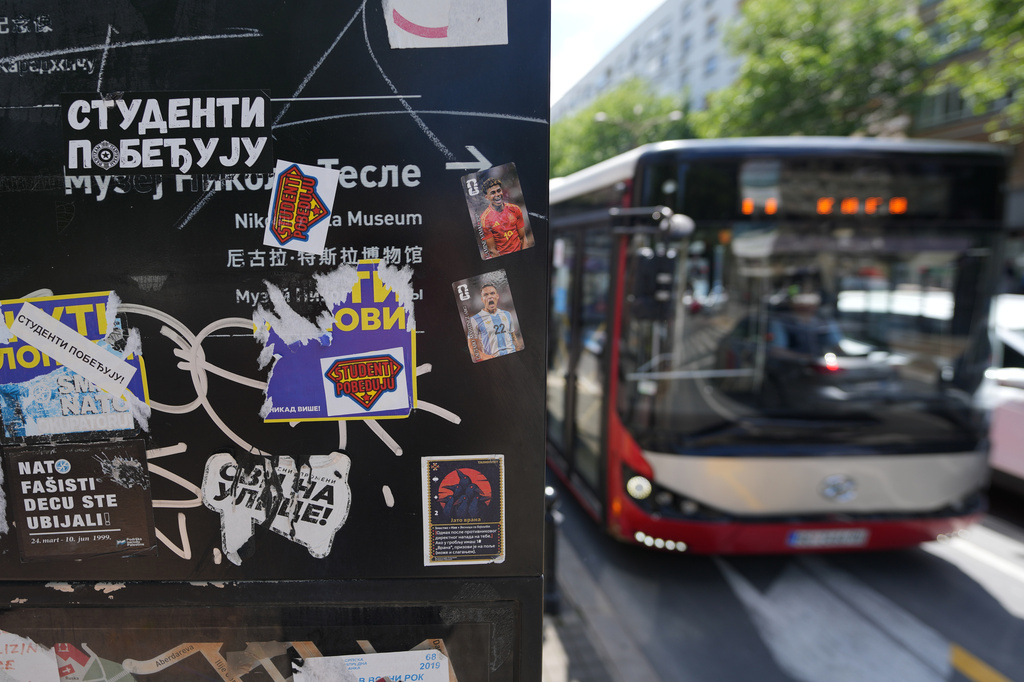 City bus passes by a sign covered with stickers that read: "Students win" before the first big rally this year of opponents of President Aleksandar Vucic in Belgrade, Serbia, Monday, May 18, 2026. (AP Photo/Darko Vojinovic)