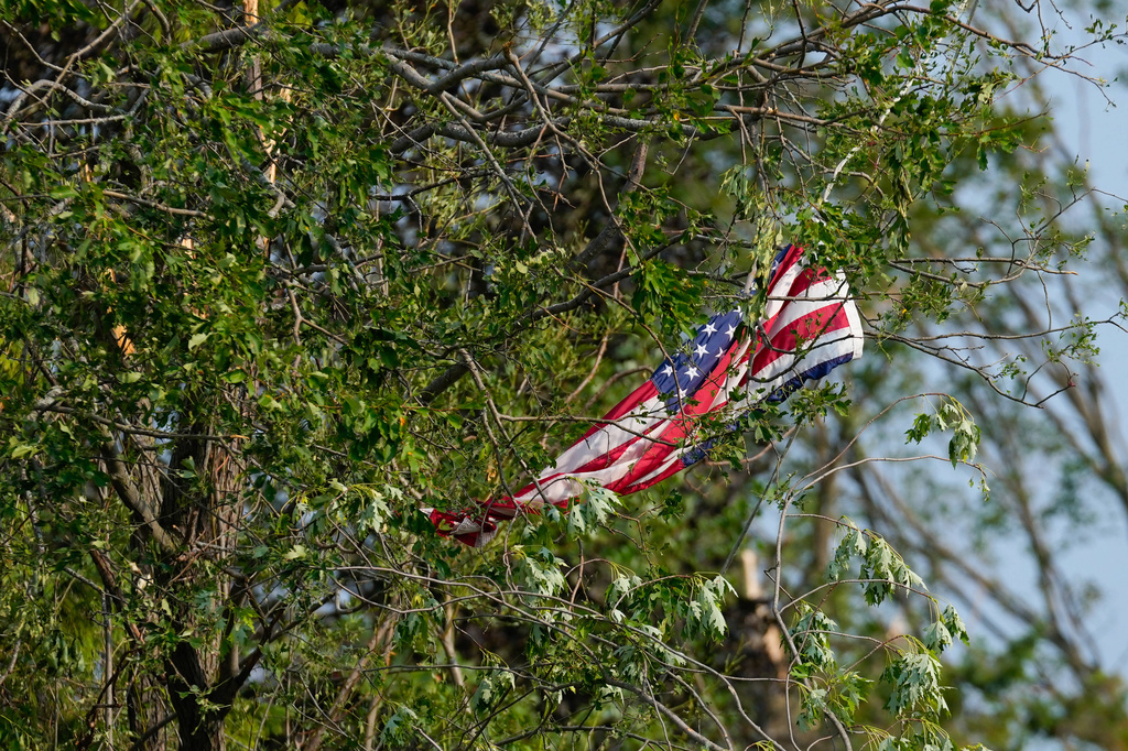 An American flag is tangled in the branches of a tree after a tornado tore through Appleton, Wis., Tuesday, July 28, 2026. (AP Photo/Kayla Wolf)