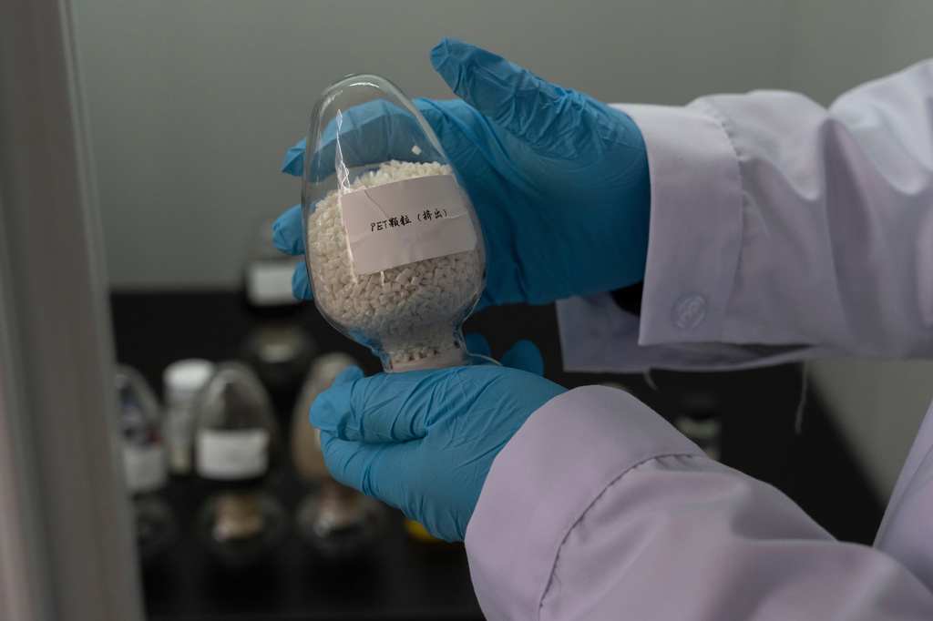 A worker holds up a sample of PET the end product from recycling polyester in used clothes at a textile sorting facility that employ's Databeyond's Fastsort-Textile AI sorting machine in Zhangjiagang in eastern China's Jiangsu province on March 20, 2026. (AP Photo/Ng Han Guan)
