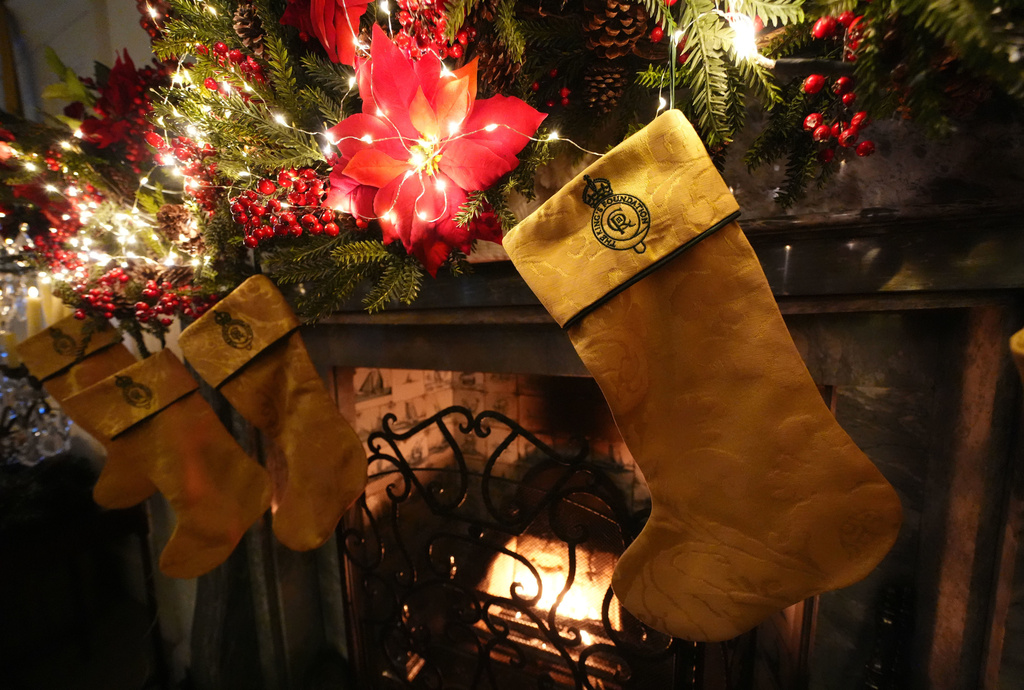 Christmas stockings created by members of the King's Foundation Sewing Bee group, which have been made using curtains repurposed from the Sandringham Estate in Norfolk, are hung from the fireplace in the Yellow drawing room at Dumfries House, which is part of The King's Foundation near Cumnock, Ayrshire, Scotland, Tuesday, Nov. 25, 2025. (Andrew Milligan/PA via AP)