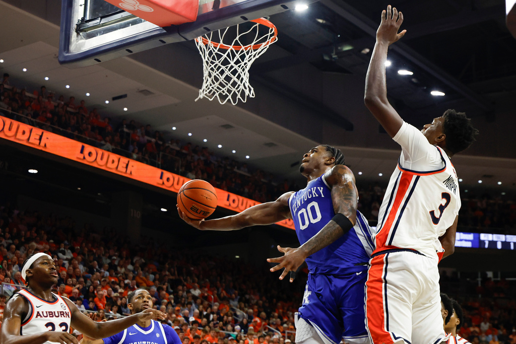 Kentucky guard Otega Oweh (00) lays in a basket as Auburn forward Keshawn Murphy (3) defends during the first half of an NCAA college basketball game Saturday, Feb. 21, 2026, in Auburn, Ala. (AP Photo/Butch Dill)
