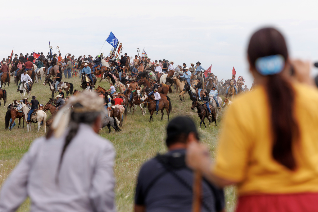 Spectators watch the annual horse charging event during festivities to commemorate the 150th anniversary of the Battle of the Little Bighorn in Crow Agency, Mont., on Thursday, June 25, 2026. (AP Photo/Tailyr Irvine)