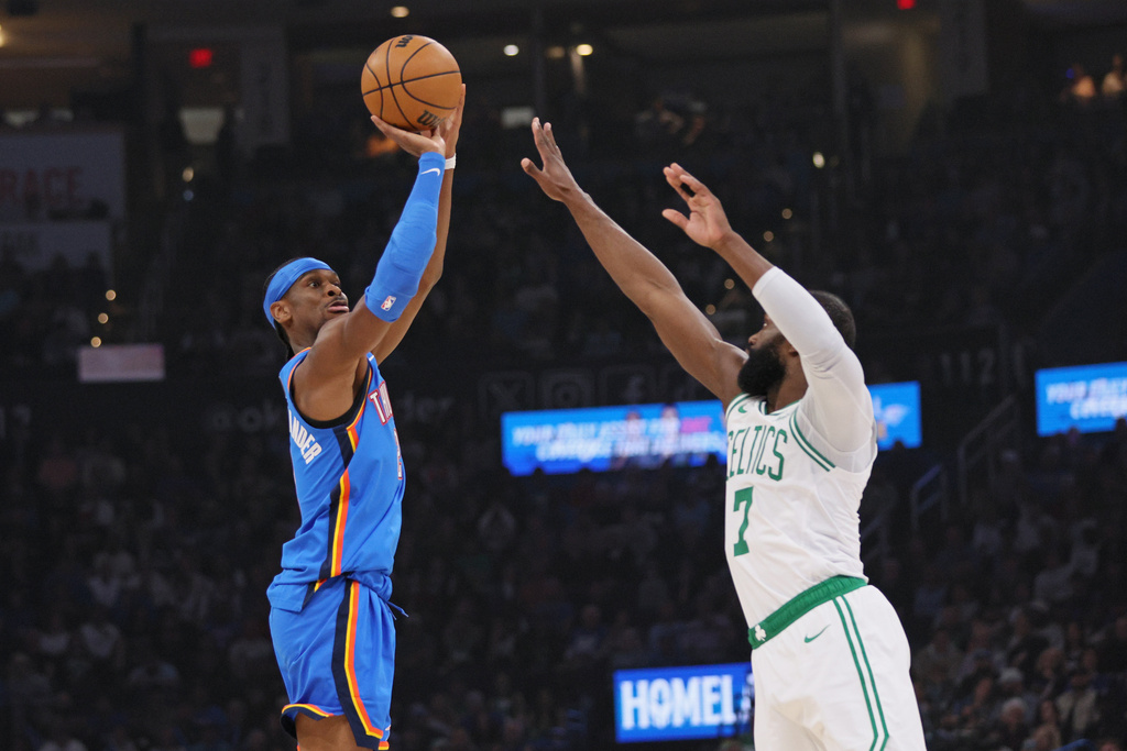 Oklahoma City Thunder guard Shai Gilgeous-Alexander, left, looks to shoot over Boston Celtics guard Jaylen Brown (7) during the first half of an NBA basketball game, Thursday, March 12, 2026, in Oklahoma City. (AP Photo/Nate Billings)