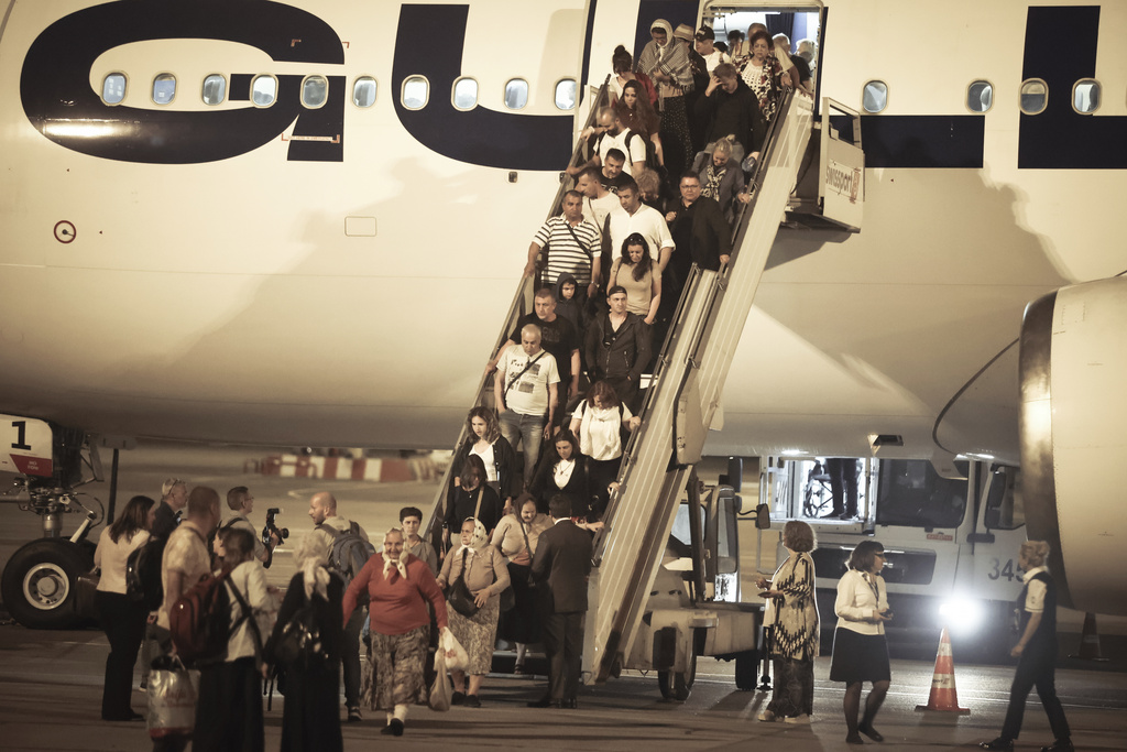 The first group of Bulgarian citizens evacuated from Israel, along with dozens of foreign nationals from Slovenia, the U.S., Belgium, Albania, Kosovo and Romania, arrive at Vassil Levsky airport in Sofia, Wednesday, June 18, 2025. (AP Photo/Valentina Petrova)