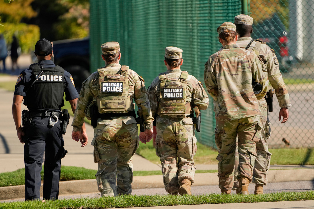 A Memphis Police Department officer, left, patrols with members of the National Guard, Friday, Oct. 10, 2025, in Memphis, Tenn. (AP Photo/George Walker IV)