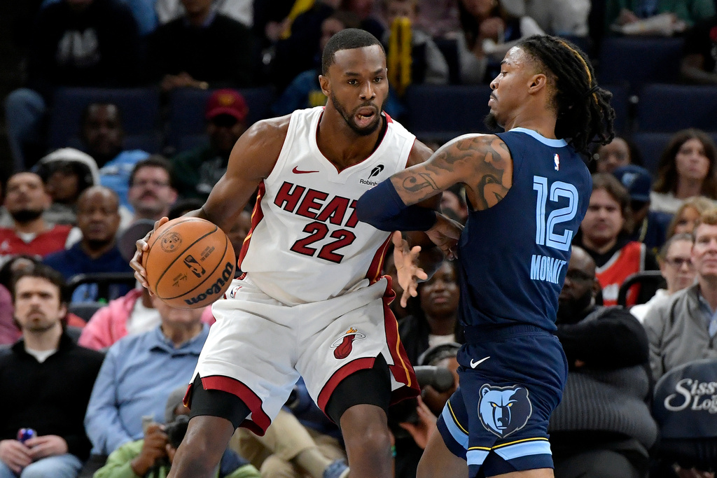 Miami Heat forward Andrew Wiggins (22) handles the ball against Memphis Grizzlies guard Ja Morant (12) in the first half of an NBA basketball game Friday, Oct. 24, 2025, in Memphis, Tenn. (AP Photo/Brandon Dill)
