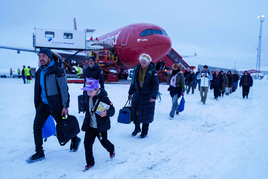 People walk out from a plane after arriving at the airport, in Nuuk, Greenland, on Monday, Jan. 12, 2026. (AP Photo/Evgeniy Maloletka)