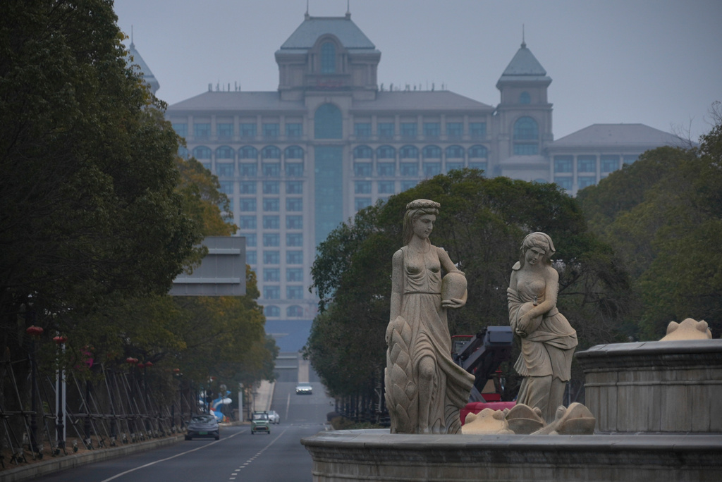 Stone statues stand over a waterless fountain by a vast, largely empty hotel at the semi-abandoned "Life in Venice" housing complex in Qidong, on China's east coast, Feb. 5, 2026. (AP Photo/Dake Kang)
