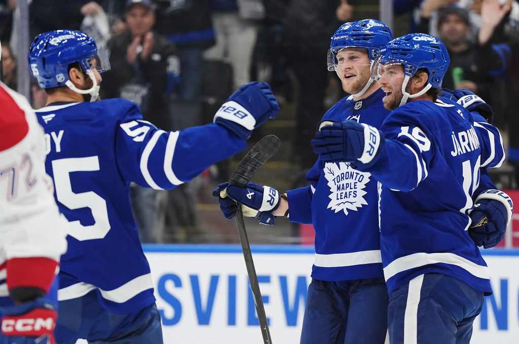 Toronto Maple Leafs' Calle Jarnkrok, right, celebrates his goal against the Montreal Canadiens with Nicolas Roy, left, and Steven Lorentz during second period NHL hockey action in Toronto on Wednesday, Oct. 8, 2025. (Frank Gunn/The Canadian Press via AP)