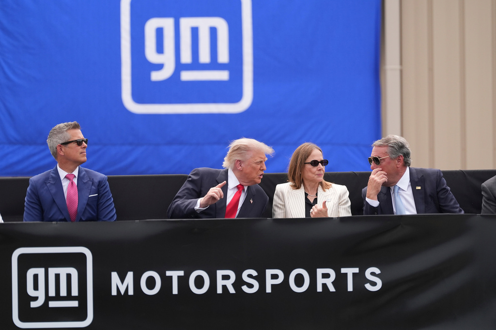 President Donald Trump, center left, speaks with Mary Barra, chair and CEO of General Motors, center right, and General Motors President Mark Reuss, right, as Transportation Secretary Sean Duffy listens at left, during a driving demonstration at General Motors proving ground, Monday, July 27, 2026, in Milford, Mich. (AP Photo/Alex Brandon)