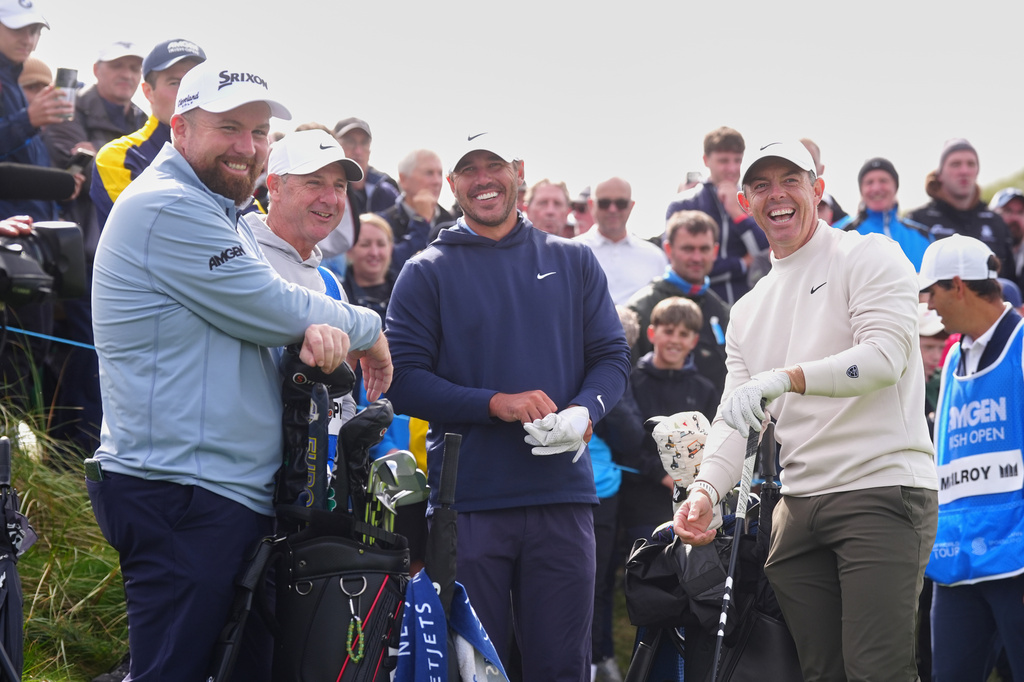Golfers, from left, Shane Lowry, of Ireland, Brooks Koepka, of the United States, and Rory McIlroy of Northern Ireland, laugh during the first round of the Irish Open golf tournament, Thursday, Sept. 10, 2026, in Doonbeg, Ireland. (Brian Lawless/PA via AP)