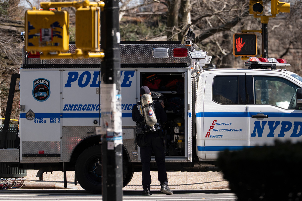 An NYPD officer carrying a oxygen tank stands outside Carl Schurz Park as they investigate suspicious device, Tuesday, March 10, 2026, in New York. (AP Photo/Yuki Iwamura)