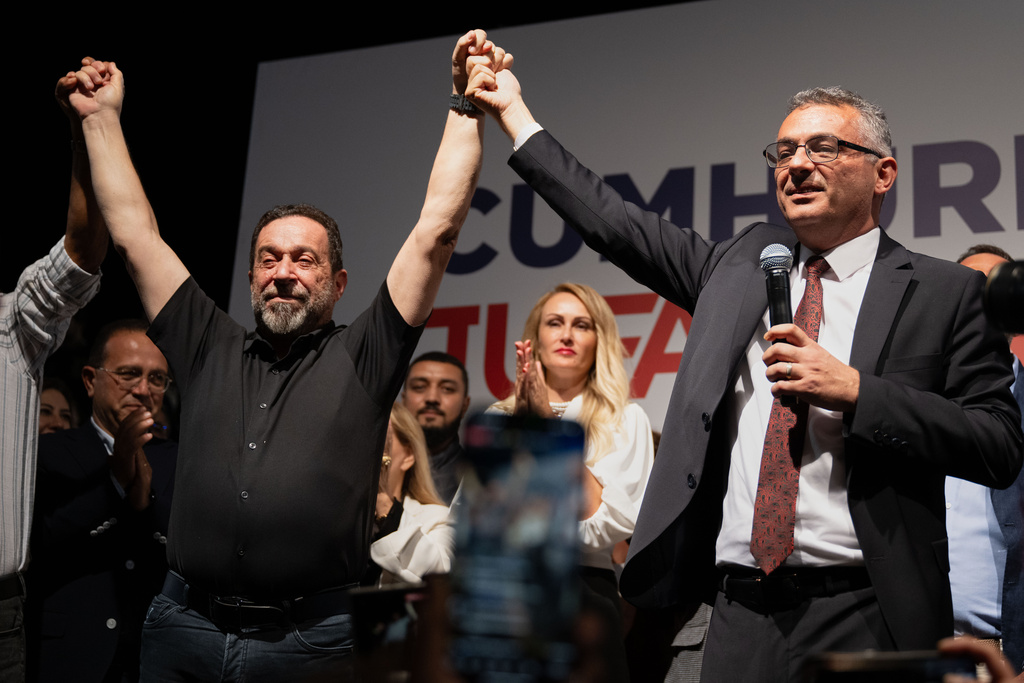 Turkish Cypriot newly elected leader Tufan Erhurman, right, and Serdar Denktash, son of the former Turkish Cypriot leader Rauf Denktash, celebrate after winning the leadership election in the Turkish occupied northern part of the divided capital Nicosia, Cyprus, Sunday, Oct. 19, 2025. (AP Photo/Nedim Enginsoy)