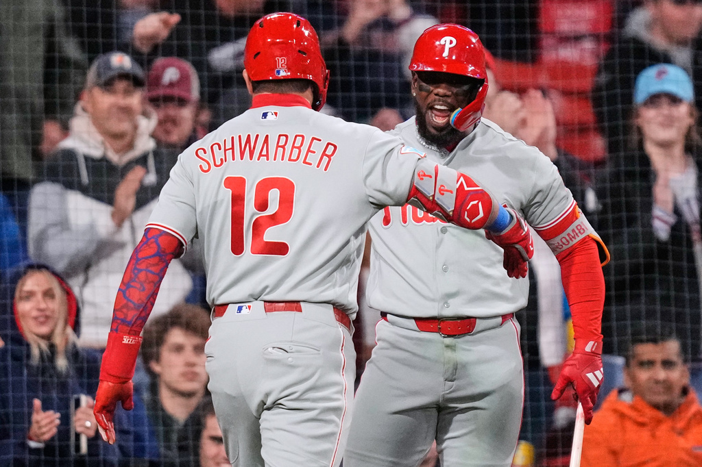 Philadelphia Phillies' Kyle Schwarber (12) is congratulated by Adolis García after his two-run home run during the eighth inning of a baseball game against the Boston Red Sox, Thursday, May 14, 2026, in Boston. (AP Photo/Charles Krupa)