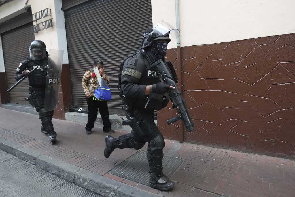 Police officers run during protests, after President Daniel Noboa eliminated the diesel subsidy in Quito, Ecuador, Tuesday, Sept. 16, 2025. (AP Photo/Dolores Ochoa)