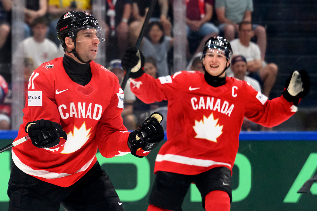 Canada's John Tavares, left, celebrates scoring with Macklin Celebrini, right, during the Group B preliminary round between the Czech Republic and Canada at the men's ice hockey world championship in Fribourg, Switzerland, Tuesday, May 26, 2026. (Laurent Gillieron/Keystone via AP)
