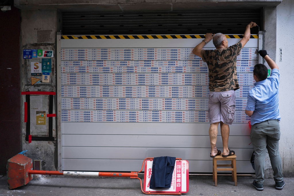 In this photo released by Xinhua News Agency, residents install flood barriers at a doorway of a building ahead of approaching Super Typhoon Ragasa, in Macao, Tuesday, Sept. 23, 2025. (Cheong Kam Ka/Xinhua via AP)