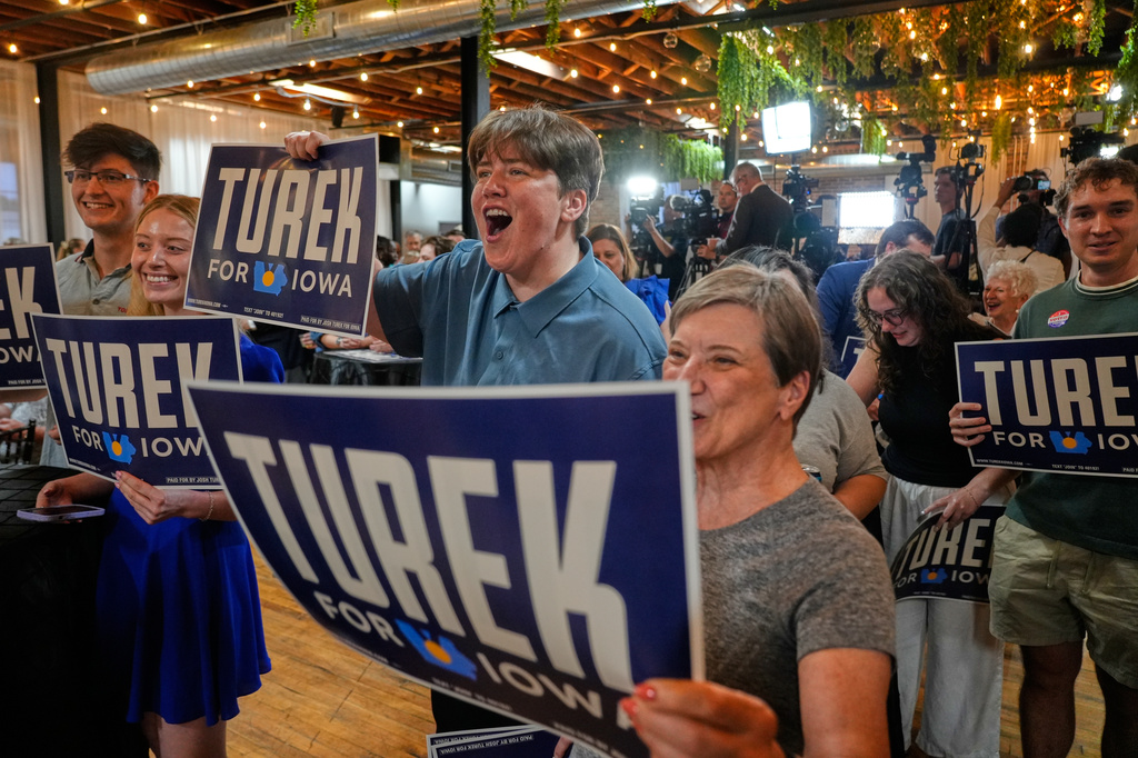 Supporters of Iowa state Rep. Josh Turek, a Democratic candidate for U.S. Senate, hold signs in support of Turek during a primary election night watch party Tuesday, June 2, 2026, in Des Moines, Iowa. (AP Photo/Bryon Houlgrave)