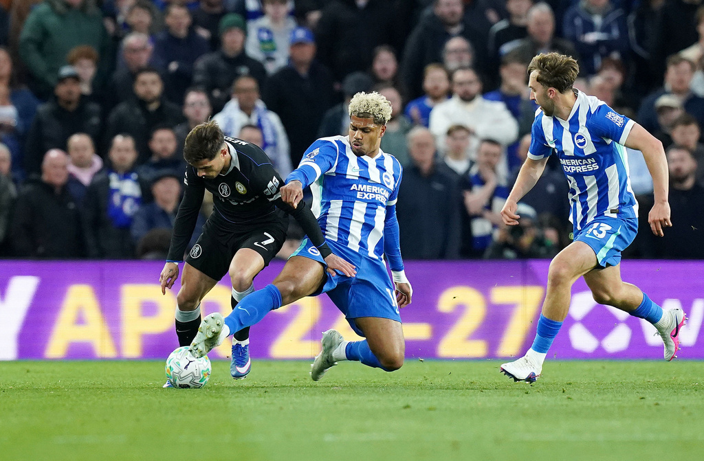 Chelsea's Pedro Neto, left, is tackled by Brighton and Hove Albion's Georginio Rutter during the English Premier League soccer match between Brighton & Hove Albion and Chelsea in Brighton, England, Tuesday, April 21, 2026. (Gareth Fuller/PA via AP)
