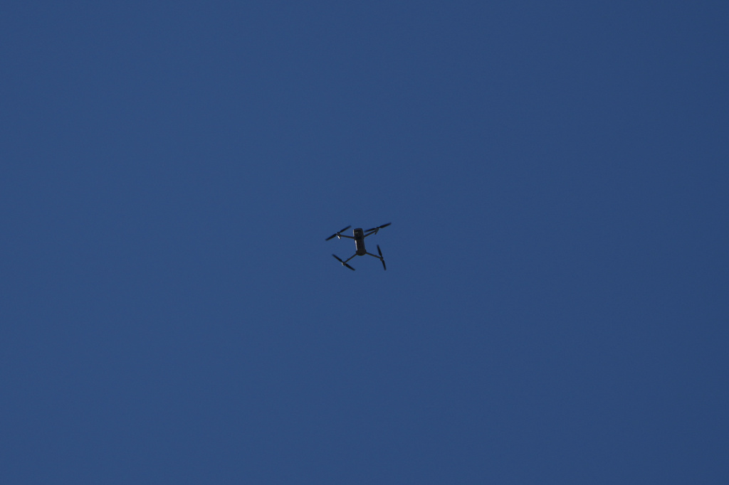 An Israeli drone flies overhead as journalists, Lebanese soldiers and residents gather in Zawtar al-Gharbieh, Lebanon, Tuesday, July 28, 2026. (AP Photo/Hassan Ammar)
