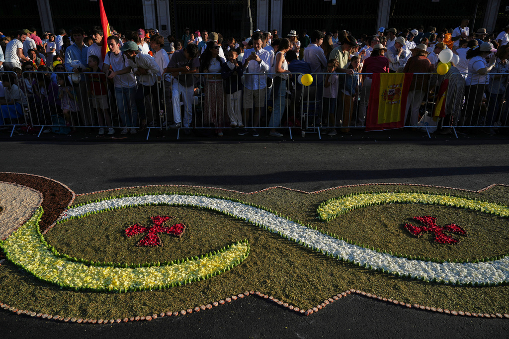 People wait for Pope Leo XIV to preside over Mass marking the Catholic feast of Corpus Christi in Plaza de Cibeles in Madrid, Sunday, June 7, 2026, on the second day of a seven-day apostolic journey to mainland Spain and the Canary Islands. (AP Photo/Alessandra Tarantino)