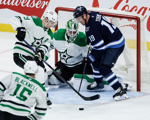Dallas Stars' Esa Lindell (23) and goaltender Jake Oettinger, center top, defend against Winnipeg Jets' Jonathan Toews (19) during second-period NHL hockey game action in Winnipeg, Manitoba, Thursday, Oct. 9, 2025. (John Woods/The Canadian Press via AP) Dallas Stars' Esa Lindell (23) and goaltender Jake Oettinger, center top, defend against Winnipeg Jets' Jonathan Toews (19) during second-period NHL hockey game action in Winnipeg, Manitoba, Thursday, Oct. 9, 2025. (John Woods/The Canadian Press via AP)