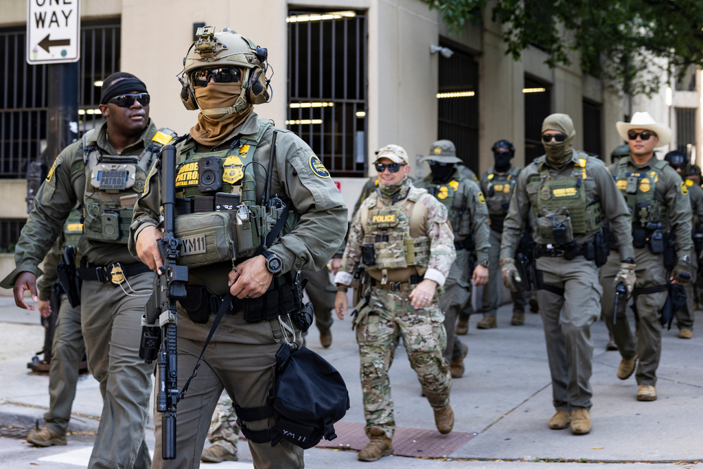 Federal agents from U.S. Immigration and Customs Enforcement and U.S. Customs and Border Protection walk north on North Clark Street in the River North neighborhood, Sunday, Sept. 28, 2025, in Chicagp. (Ashlee Rezin/Chicago Sun-Times via AP)
