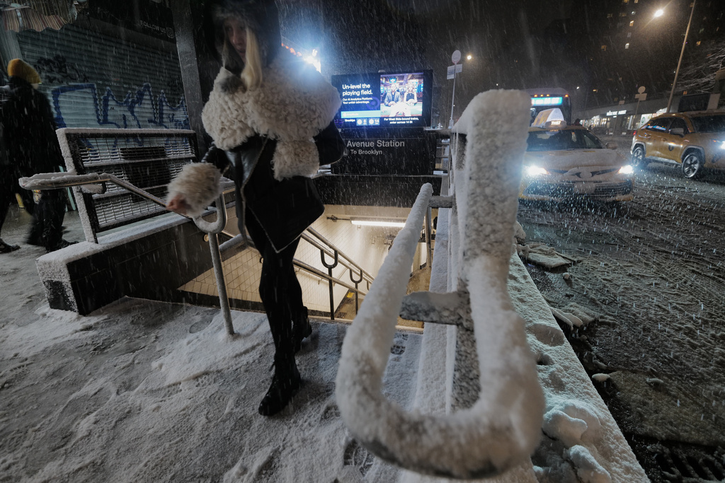 A passenger exits a subway station as snow falls in the Alphabet City neighborhood of New York, Sunday evening, Feb. 22, 2026. (AP Photo/Patrick Sison)