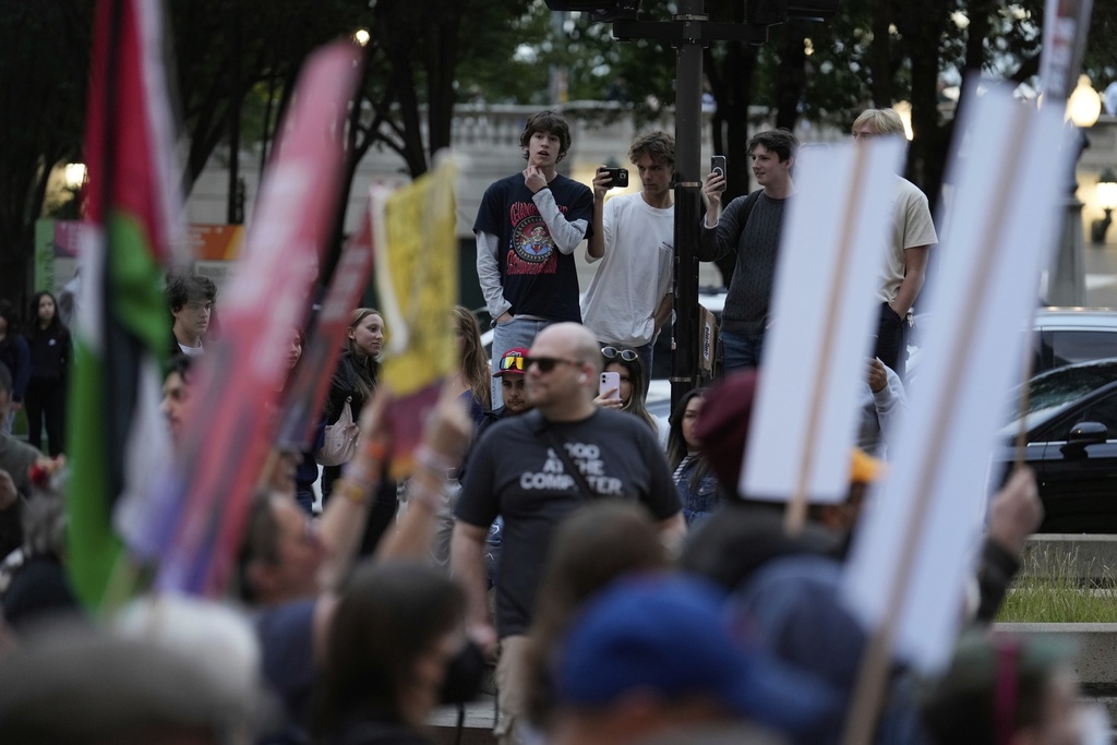 Bystandars take pictures as people march during Illinois Coalition for Immigrant & Refugee Rights' "Chicago Says No Trump No Troops" protest Saturday, Sept. 6, 2025, in Chicago. (AP Photo/Carolyn Kaster)