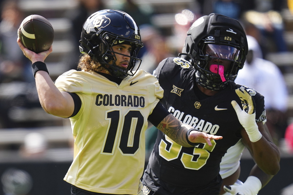 FILE - Colorado quarterback Julian Lewis (10) throws under pressure from defensive end Arden Walker (53) during Colorado's NCAA college football spring game, April 19, 2025, in Boulder, Colo. (AP Photo/Jack Dempsey, file)
