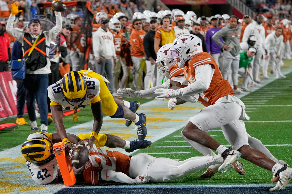 Michigan quarterback Bryce Underwood (19) crosses the goal line for a touchdown against Texas during the second half of the Citrus Bowl NCAA college football game, Wednesday, Dec. 31, 2025, in Orlando, Fla. (AP Photo/John Raoux)