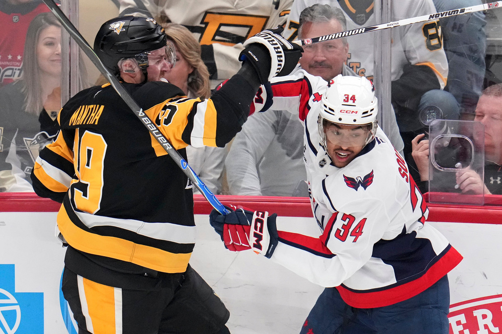 Washington Capitals' Justin Sourdif (34) battles Pittsburgh Penguins' Anthony Mantha (39) during the first period of an NHL hockey game in Pittsburgh, Saturday, April 11, 2026. (AP Photo/Gene J. Puskar)