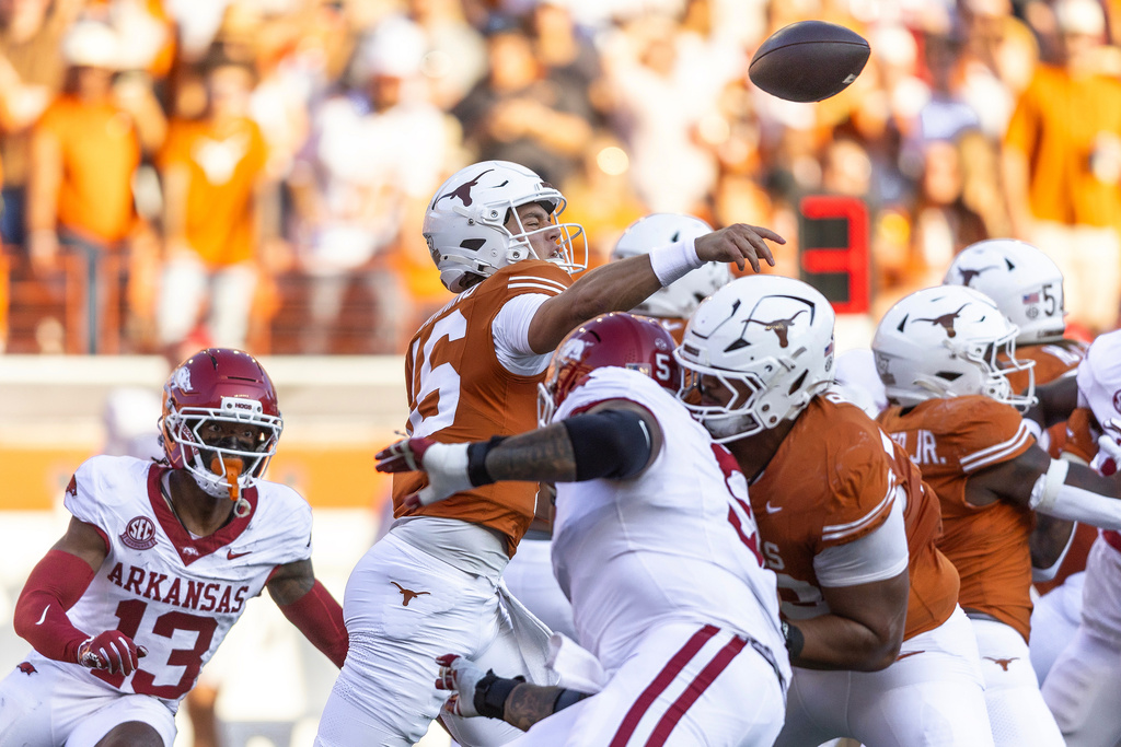 Arkansas defensive back Kani Walker (13) watches as Texas quarterback Arch Manning (16) throws under pressure during the first half of an NCAA college football game Saturday, Nov. 22, 2025, in Austin, Texas. (AP Photo/Stephen Spillman)