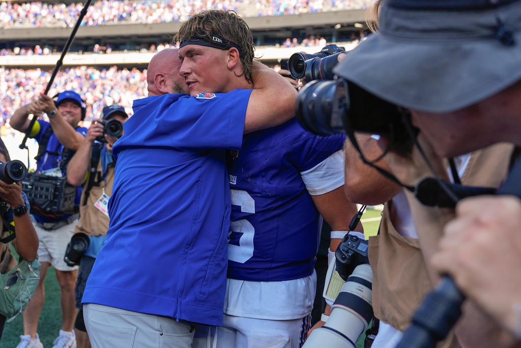 New York Giants quarterback Jaxson Dart (6) gets a hug from head coach Brian Daboll after the Giants defeated the Los Angeles Chargers in an NFL football game, Sunday, Sept. 28, 2025, in East Rutherford, N.J. (AP Photo/Yuki Iwamura)