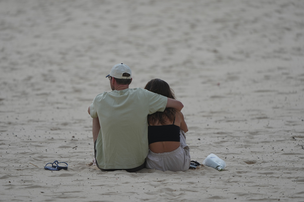 A couple embrace a day after a shooting at Sydney's Bondi Beach, Monday, Dec. 15, 2025. (AP Photo/Mark Baker)