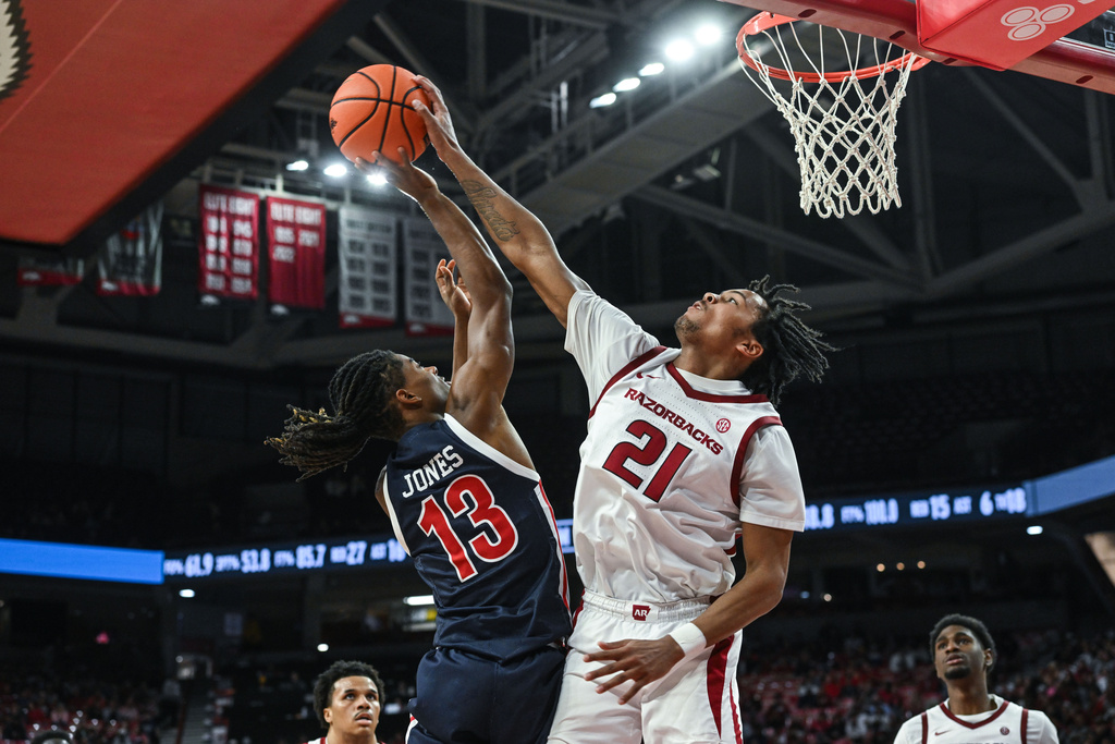 Arkansas guard D.J. Wagner (21) blocks a shot by Jackson State guard Cael Jones (13) during the second half of an NCAA college basketball game Friday, Nov. 21, 2025, in Fayetteville, Ark. (AP Photo/Michael Woods)
