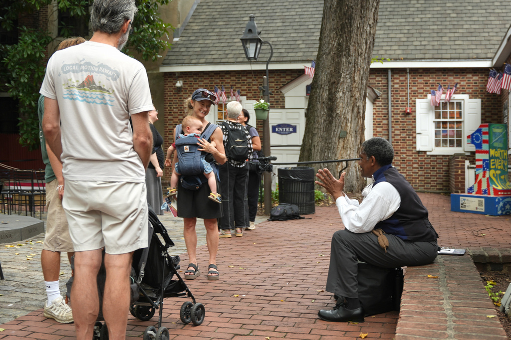 Historic reenactor Keith Henley, performing as the abolitionist James Fowler, right, greets visitors at the Betsy Ross House on July 28, 2026, in Philadelphia. (AP Photo/Mingson Lau)