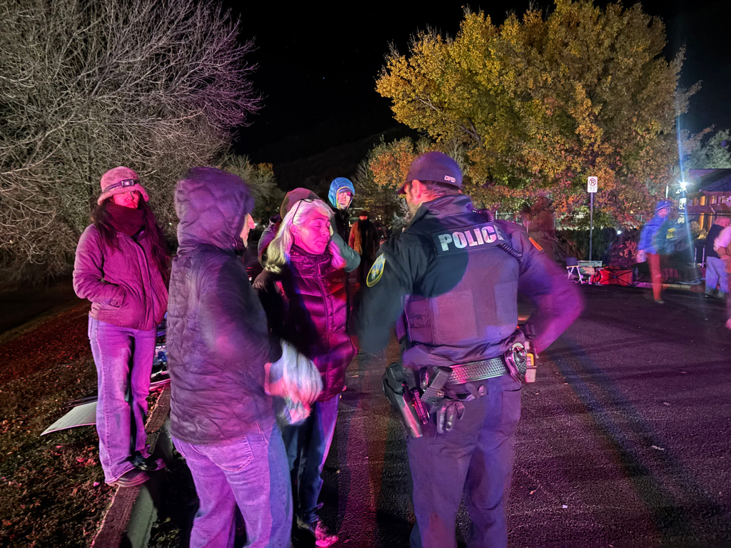 Franci Stagi center, speaks with a Durango, Colo., Police Department officer early Oct. 29, 2025, after an immigration officer allegedly assaulted her in Durango, Colo. (Scout Edmondson/Durango Herald via AP)