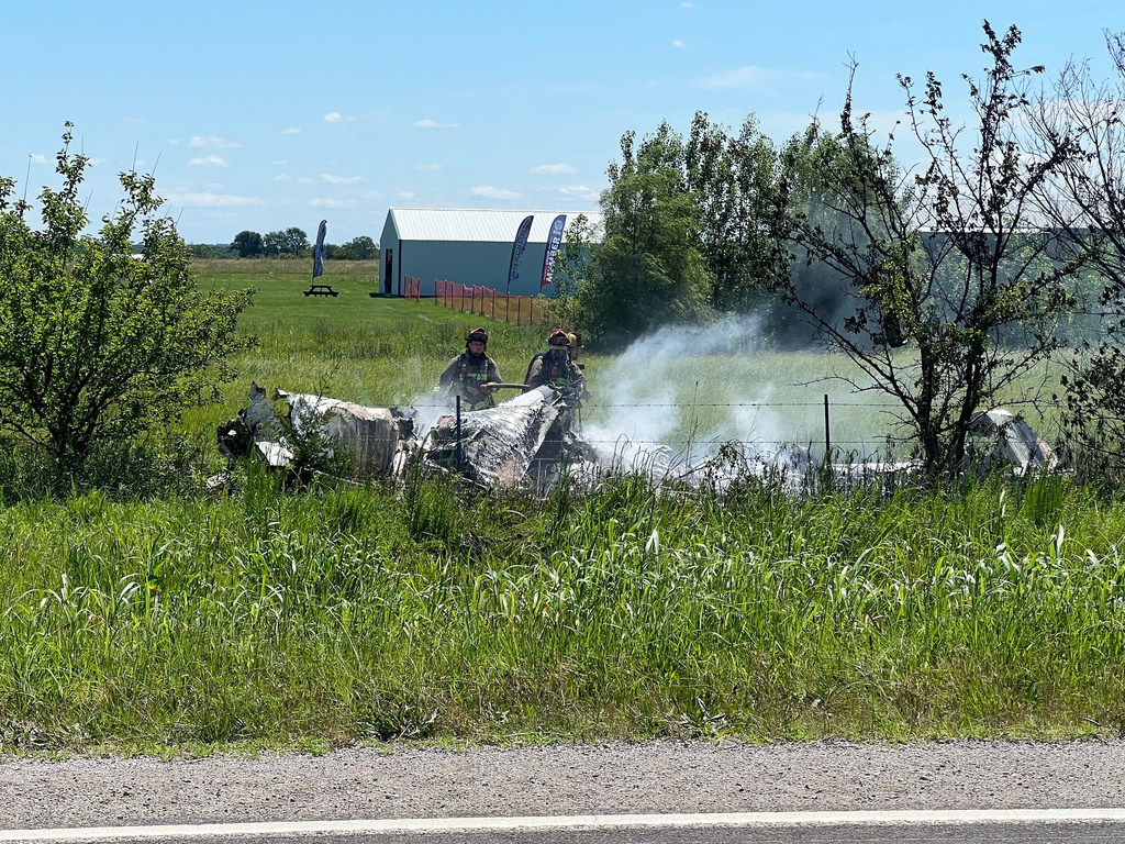 The wreckage of a plane crash burns in a field in Butler, Mo, Sunday, June 14, 2026. (Mid America News Review via AP Photo )
