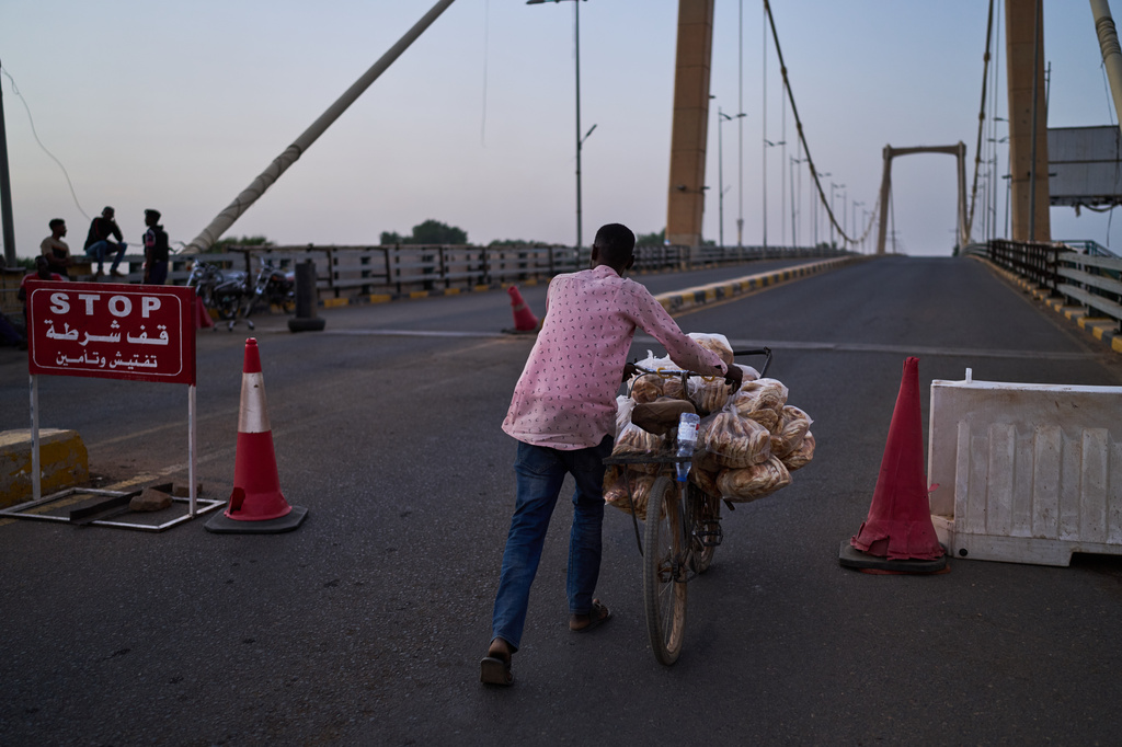 A man pushes his bicycle through a checkpoint in Khartoum, Sudan, Tuesday, April 21, 2026. (AP Photo/Bernat Armangue)