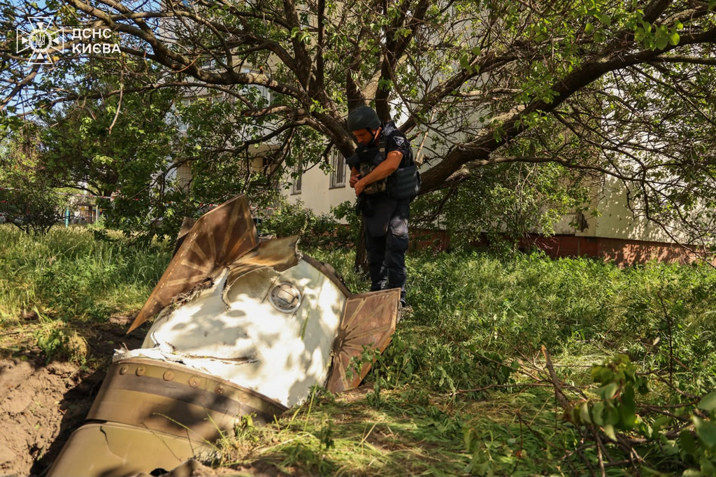In this photo provided by the Ukrainian Emergency Service, a sapper examines a fragment of the Russian missile in a residential neighbourhood following an air attack in Kyiv, Ukraine, Sunday, June 28, 2026. (Ukrainian Emergency Service via AP)