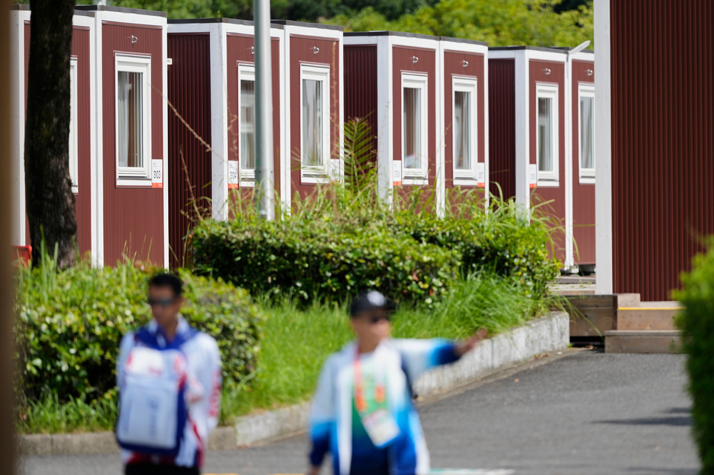 Officials stand outside the athletes accommodation huts at the Athletes Village ahead of the Asian Games Nagoya, Japan, Friday, Sept. 18, 2026. (AP Photo/Dita Alangkara)