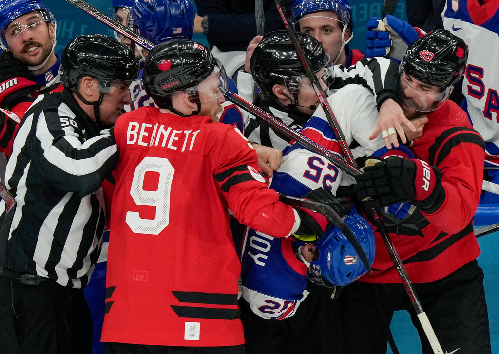 Referees try to break up a fight between Canada's Sam Bennett (9), United States' Charlie McAvoy (25) and Canada's Tom Wilson (43) during the second period of the men's ice hockey gold medal game at the 2026 Winter Olympics, in Milan, Italy, Sunday, Feb. 22, 2026. (AP Photo/Luca Bruno)