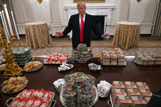 FILE - President Donald Trump talks to reporters about the table full of fast food in the State Dining Room of the White House in Washington, Jan. 14, 2019, for the reception for the Clemson Tigers. (AP Photo/Susan Walsh) FILE - President Donald Trump talks to reporters about the table full of fast food in the State Dining Room of the White House in Washington, Jan. 14, 2019, for the reception for the Clemson Tigers. (AP Photo/Susan Walsh)