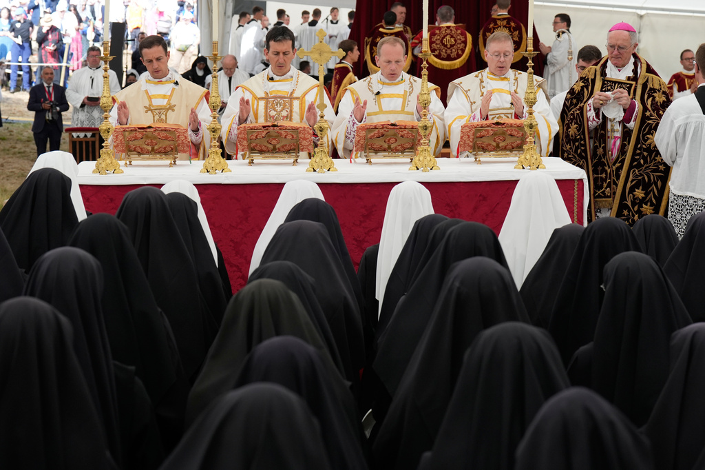 From left Marc Hanappier, Michel Poinsinet de Sivry, Michael Goldade and Pascal Schreiber pray during their consecration ceremony as bishops in a tent set up outside the Society of St. Pius X seminary, in Econe, Switzerland, Wednesday, July 1, 2026. (AP Photo/Baz Ratner)
