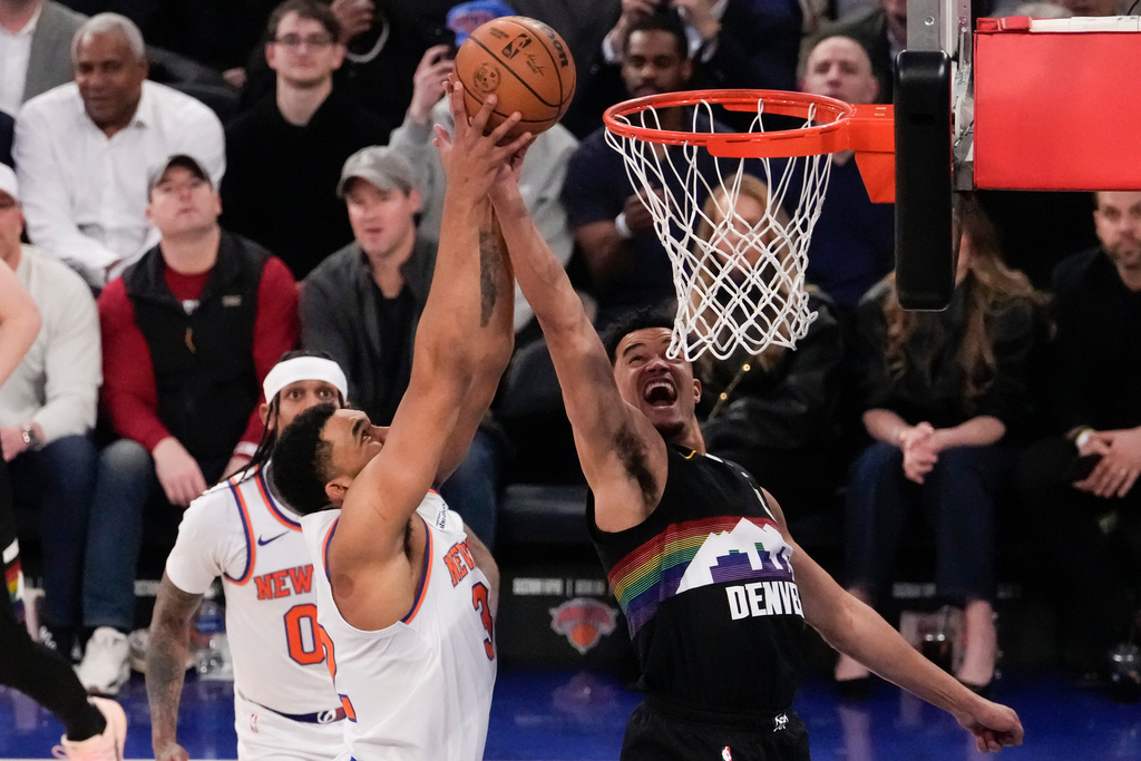 Denver Nuggets forward Spencer Jones (21) fights for control of the ball with New York Knicks center Karl-Anthony Towns (32) during the first half of an NBA basketball game, Wednesday, Feb. 4, 2026, in New York. (AP Photo/Yuki Iwamura)