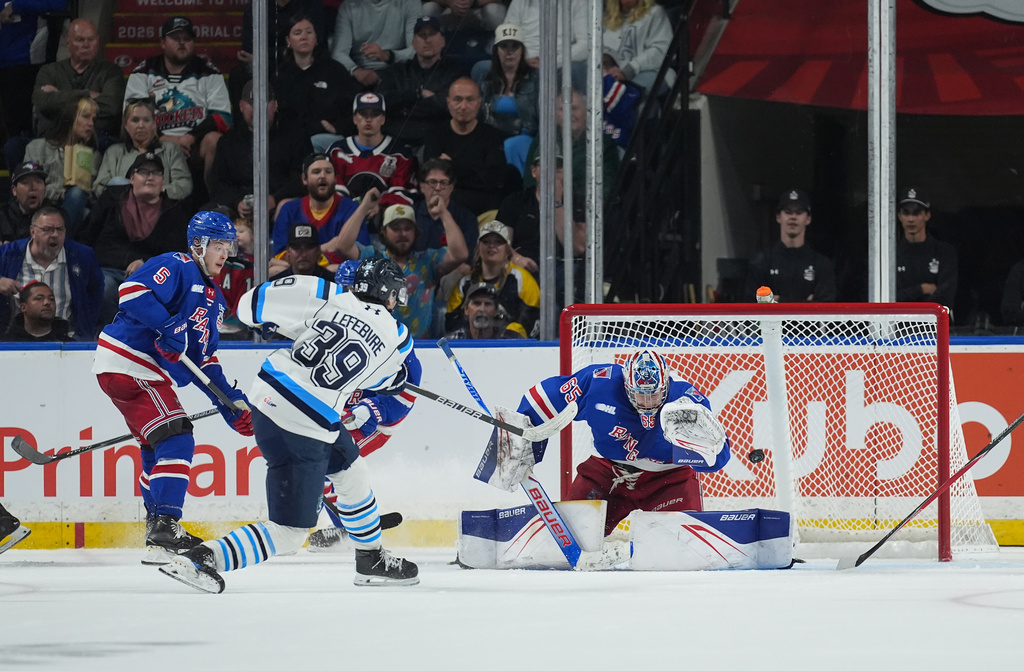 Kitchener Rangers goalie Christian Kirsch (65) stops Chicoutimi Sagueneens' Liam Lefebvre (39) during the second period of a Memorial Cup hockey game, in Kelowna, B.C., on Tuesday, May 26, 2026. (Darryl Dyck/The Canadian Press via AP)