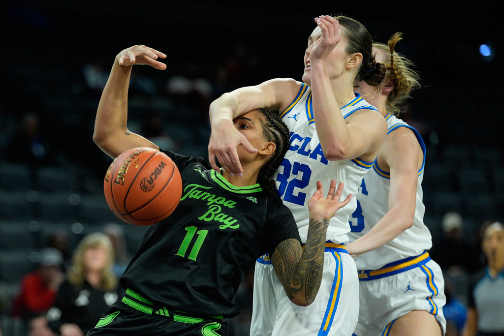 UCLA forward Angela Dugalic (32) blocks a shot attempt by South Florida guard Kirsten Lewis-Williams (11) during the second half of an NCAA college basketball game Saturday, Nov. 15, 2025, in Las Vegas. (AP Photo/John Locher)