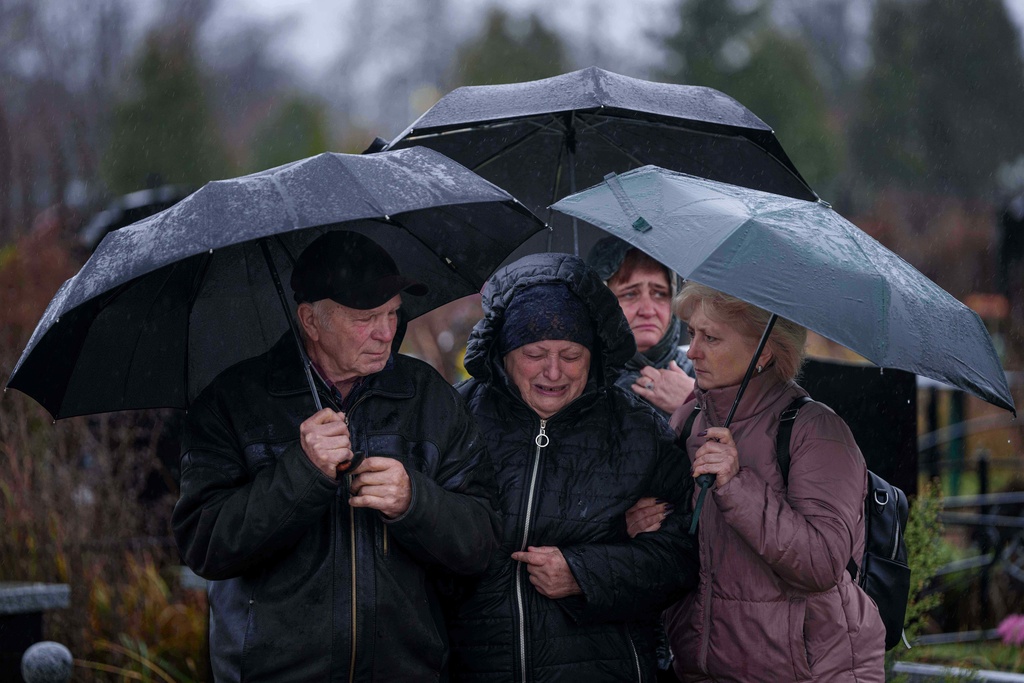 Parents Natalia and Anatoliy cry at the coffin of their son Ruslan Zhygunov, a Ukrainian serviceman, who was killed at the frontline near Rusyn Yar village, during his funeral ceremony in Hostomel, Ukraine, on Saturday, Nov. 22, 2025. (AP Photo/Evgeniy Maloletka)